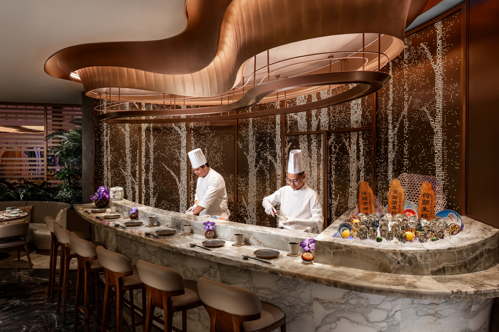 Welcoming guests on the other side of the entrance is the marble oyster counter, where guests can witness their delicacies freshly shucked to serve.